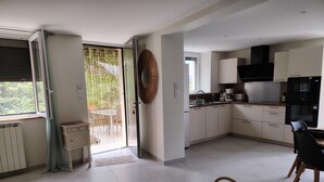 Una cocina moderna con armarios blancos, un refrigerador negro y una cafetera.