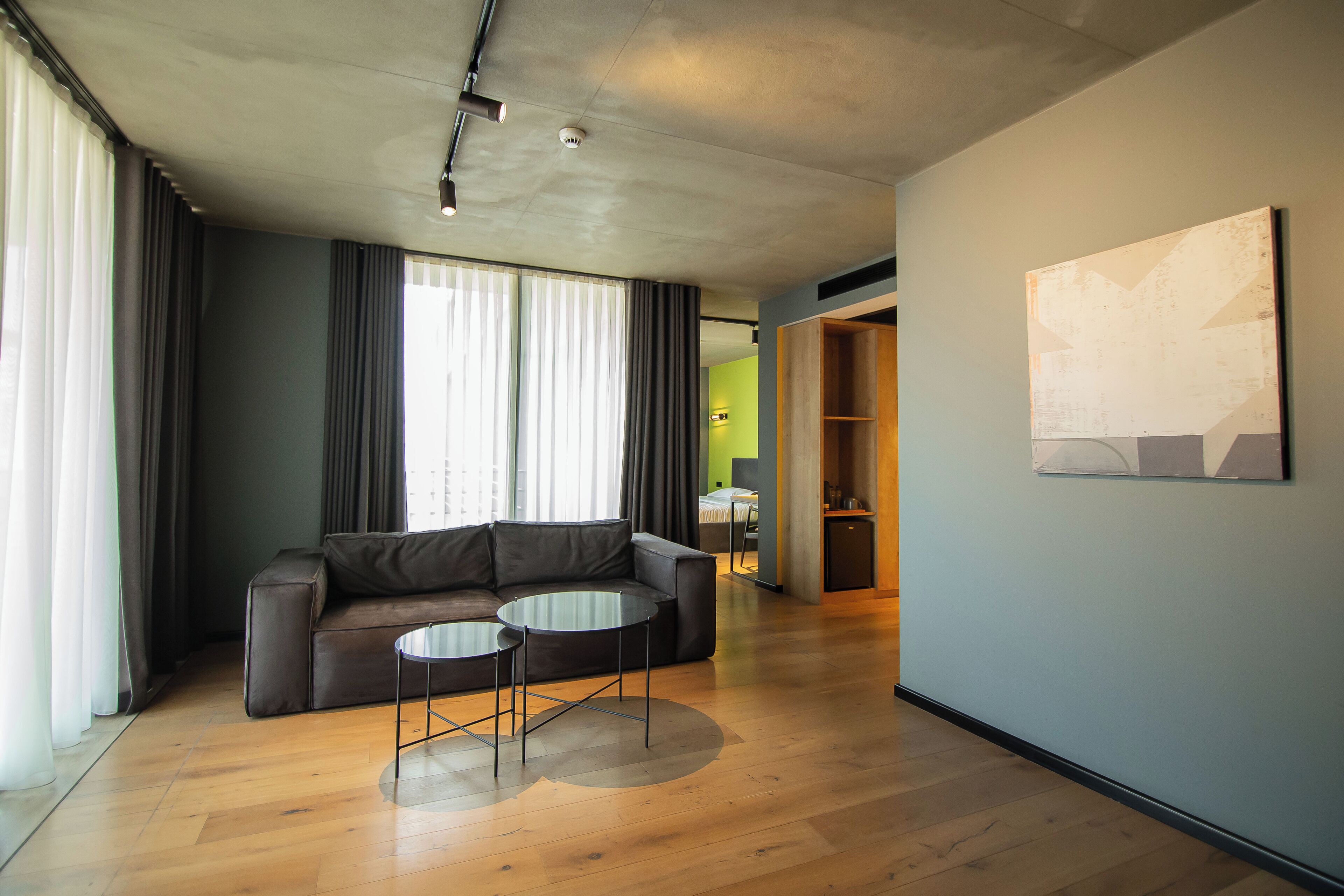 A modern living room with a leather sofa, a glass coffee table, and a wooden floor.