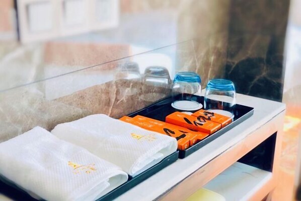 A tray with towels and toiletries on a hotel counter.