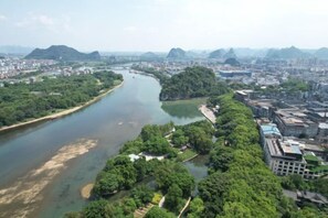 An aerial view of a city with a river, green areas, and buildings. - Dong'an Business Hotel (Guilin University of Technology Pingfeng Campus Branch) (Guilin)