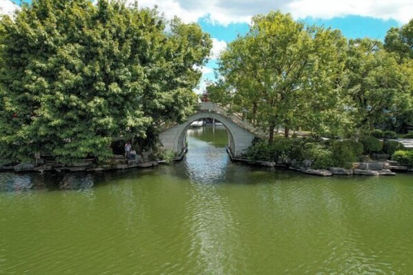 A stone bridge over a calm body of water, surrounded by lush greenery. - Dong'an Business Hotel (Guilin University of Technology Pingfeng Campus Branch) (Guilin)