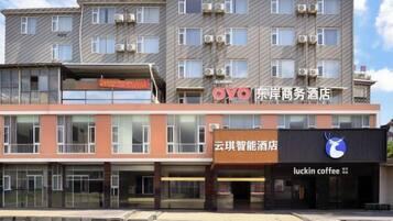 A multi-story hotel with a modern facade, featuring signage for a business hotel and a coffee shop.
