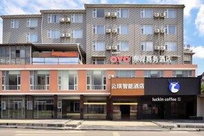 A multi-story hotel with a modern facade, featuring signage for a business hotel and a coffee shop.