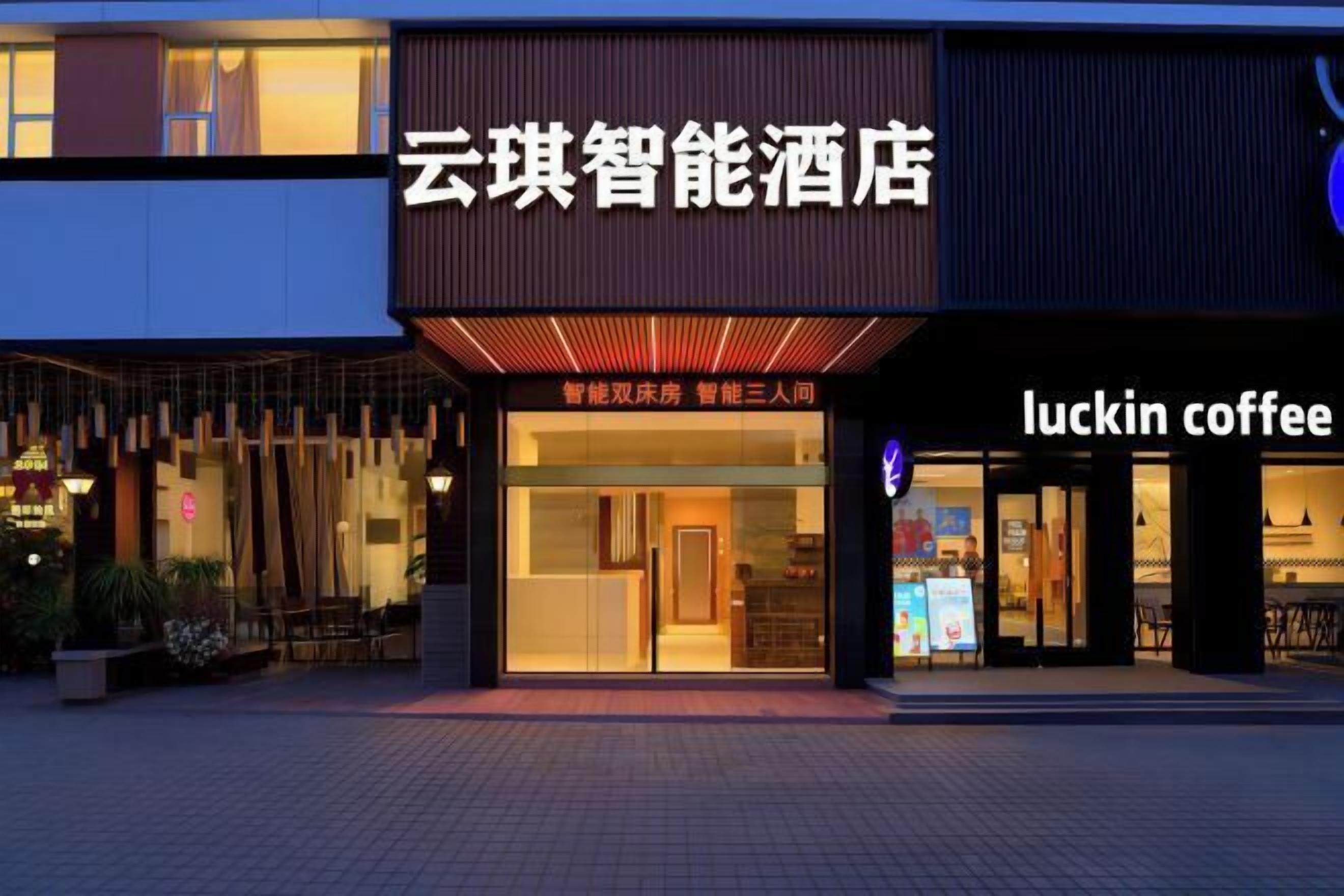 A hotel with a modern facade, a visible entrance, and a coffee shop named 'luckin coffee' adjacent to it.