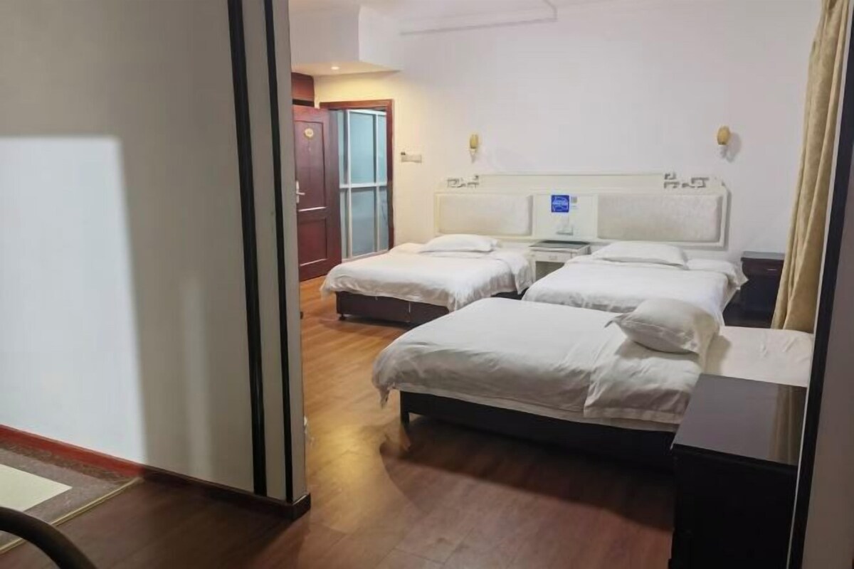 A hotel room with two beds, a desk, and a chair.