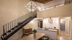 Un interior moderno con escalera, comedor, cocina y sala de estar.