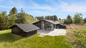 A modern house with a large deck and a separate garage. - Stunning home in ålbæk with sauna (Ålbæk)