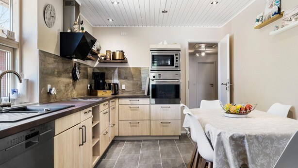 A compact kitchen with a dishwasher, a coffee maker, and a microwave. There is a dining table with a fruit bowl on it. - 3 bedroom nice home in Ulfborg (Ulfborg)