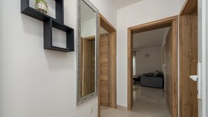 A hallway with a mirrored wall, a wooden door frame, and a tiled floor. - Amazing apartment in Maslenica with WiFi (Maslenica)