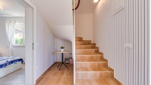 A staircase with a wooden finish leading to a landing with a small table and a potted plant. - Gorgeous home in Visnjan with private swimming pool, can be inside or outside (Visnjan)