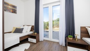 Une chambre à coucher moderne, avec un lit, des tables de chevet et une vue sur l’extérieur.