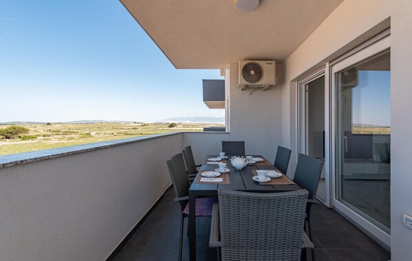 A balcony with a table set for two, overlooking a landscape. - 2 bedroom amazing apartment in Povljana (Povljana)