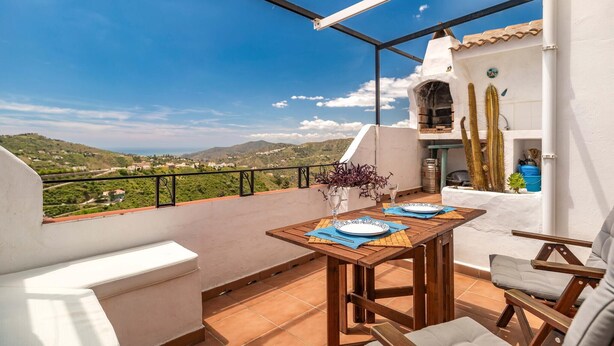 A terrace with a table set for two, a cactus, and a view of the countryside. - Gorgeous home in Cómpeta - Málaga (Cómpeta - Málaga)