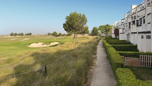 A golf course with a pathway alongside a building with multiple balconies. - Pet friendly apartment in Torrevieja with WiFi (Torrevieja)