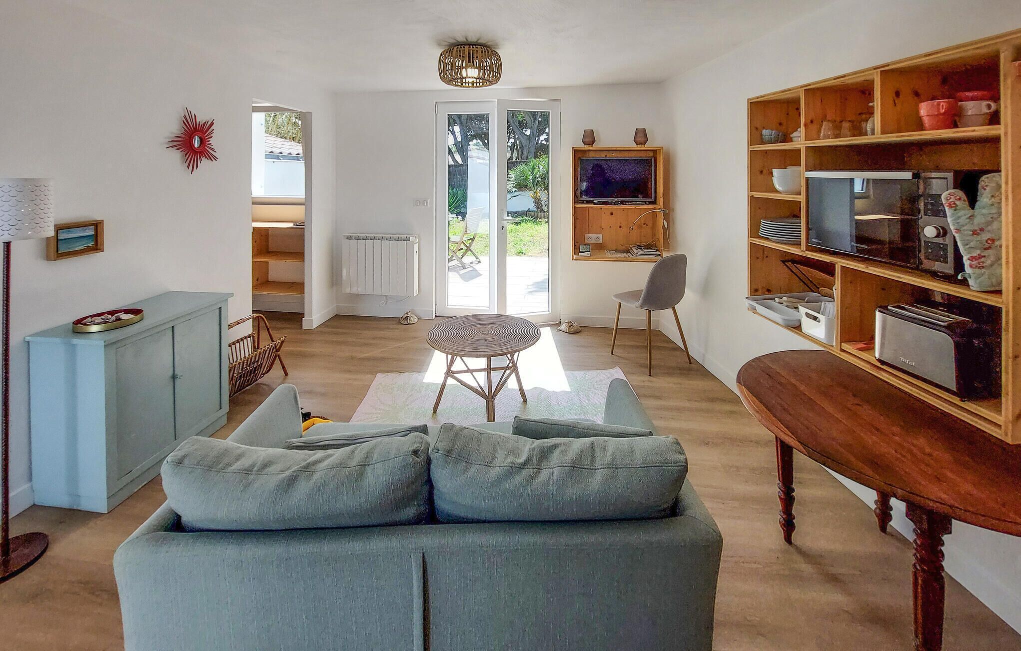 Een woonkamer met een bank, een eettafel, een televisie en een boekenkast.