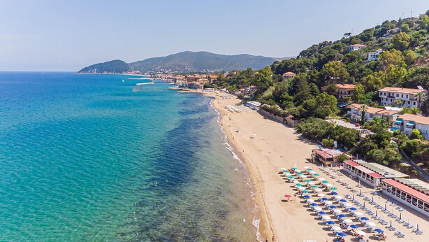 A coastal beach with clear blue waters, a sandy shore, and buildings with red roofs along the coastline. - Amazing home in Perdifumo (Perdifumo)