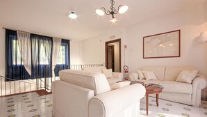 A living room with a sofa set, a coffee table, a chandelier, and a fire extinguisher. - 5 bedroom beautiful home in Sessa Cilento (Sessa Cilento)