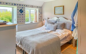 A bedroom with a bed, a window, and a painting on the wall. - 2 bedroom beautiful home in Fanø (Fanø)