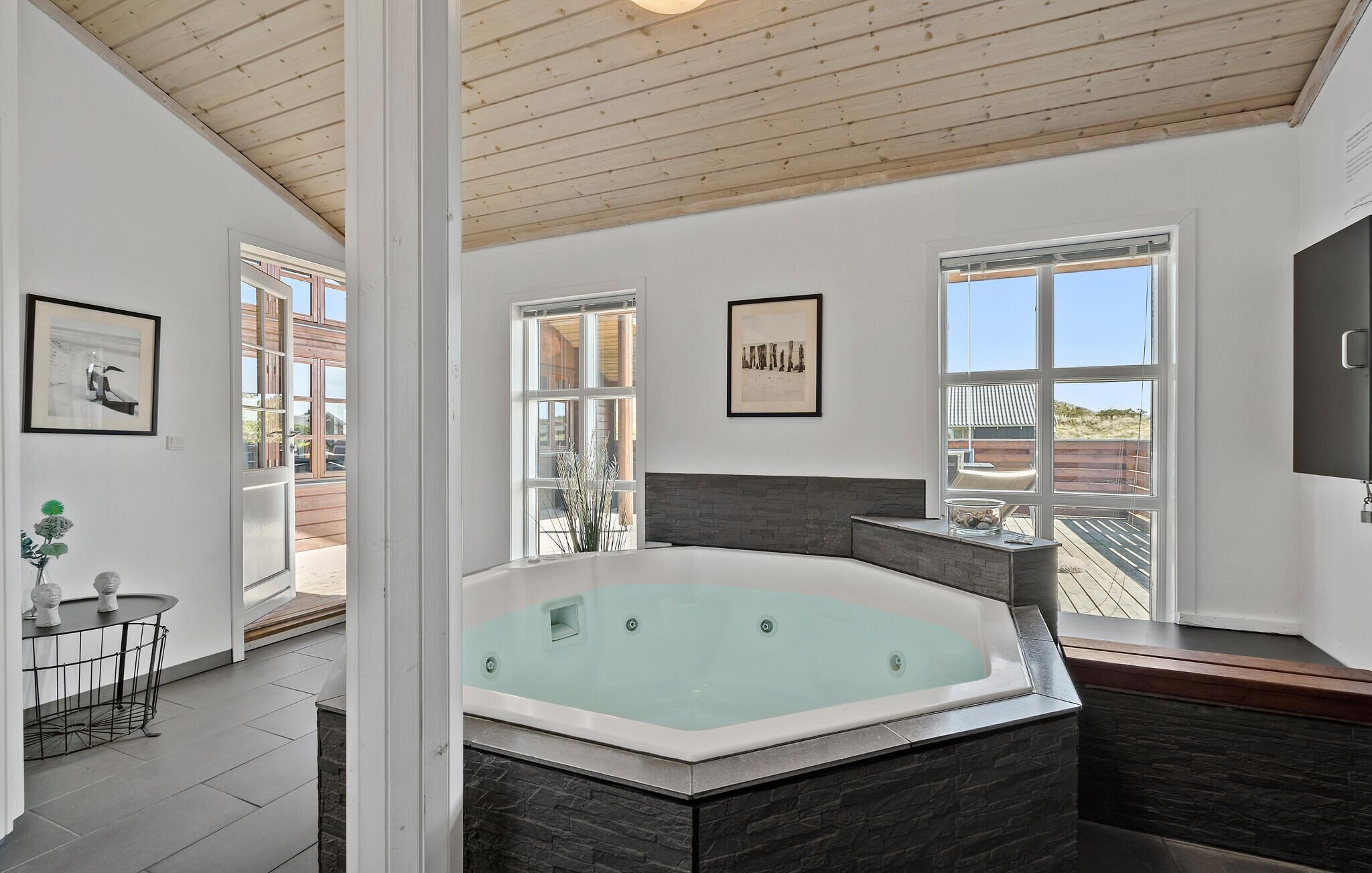 A modern bathroom with a freestanding bathtub, large windows, and a view of the outdoors.