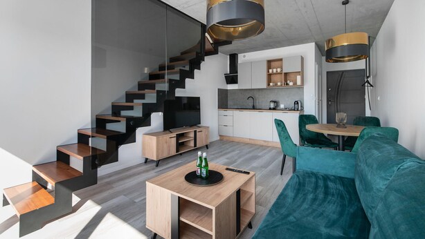 A modern apartment with a staircase, a kitchen, a dining area, and a living room. - Awesome apartment in Nowecin with sauna (Nowecin)