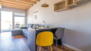 A modern kitchen with a dining area, wooden ceiling beams, and built-in shelves. - Cozy apartment in Nowecin with sauna (Nowecin)