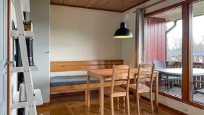 A room with a wooden bench, a table, and chairs. There is a large window with a view of the outside. - Amazing home in Degeberga (Degeberga)