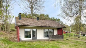 A single-story house with a tiled roof, large windows, and a covered porch. - Amazing home in Degeberga (Degeberga)