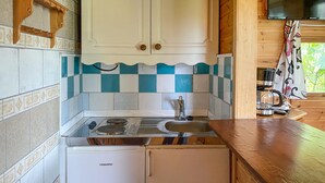 Una cocina compacta con estufa a gas, horno integrado y refrigerador.