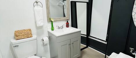 A modern bathroom with a toilet, sink, and shower area.