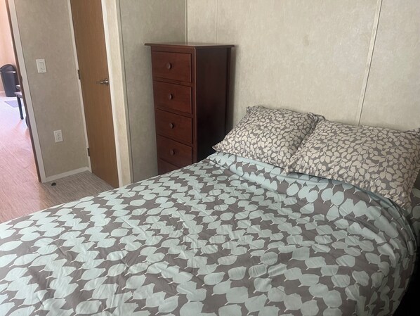 A bedroom with a bed, a dresser, and a door. - Charming 1-bedroom tiny house in awesome Chester with WiFi, central AC and Heat. (Chester)