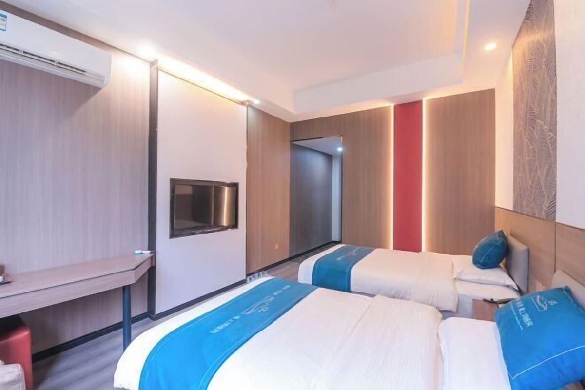 Ein Hotelzimmer mit zwei Betten, einem Schreibtisch und einem Spiegel.