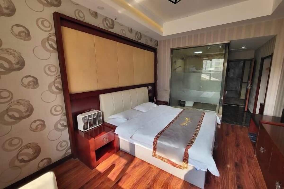 Una habitación de hotel con una cama grande, una mesita de noche y un espejo.