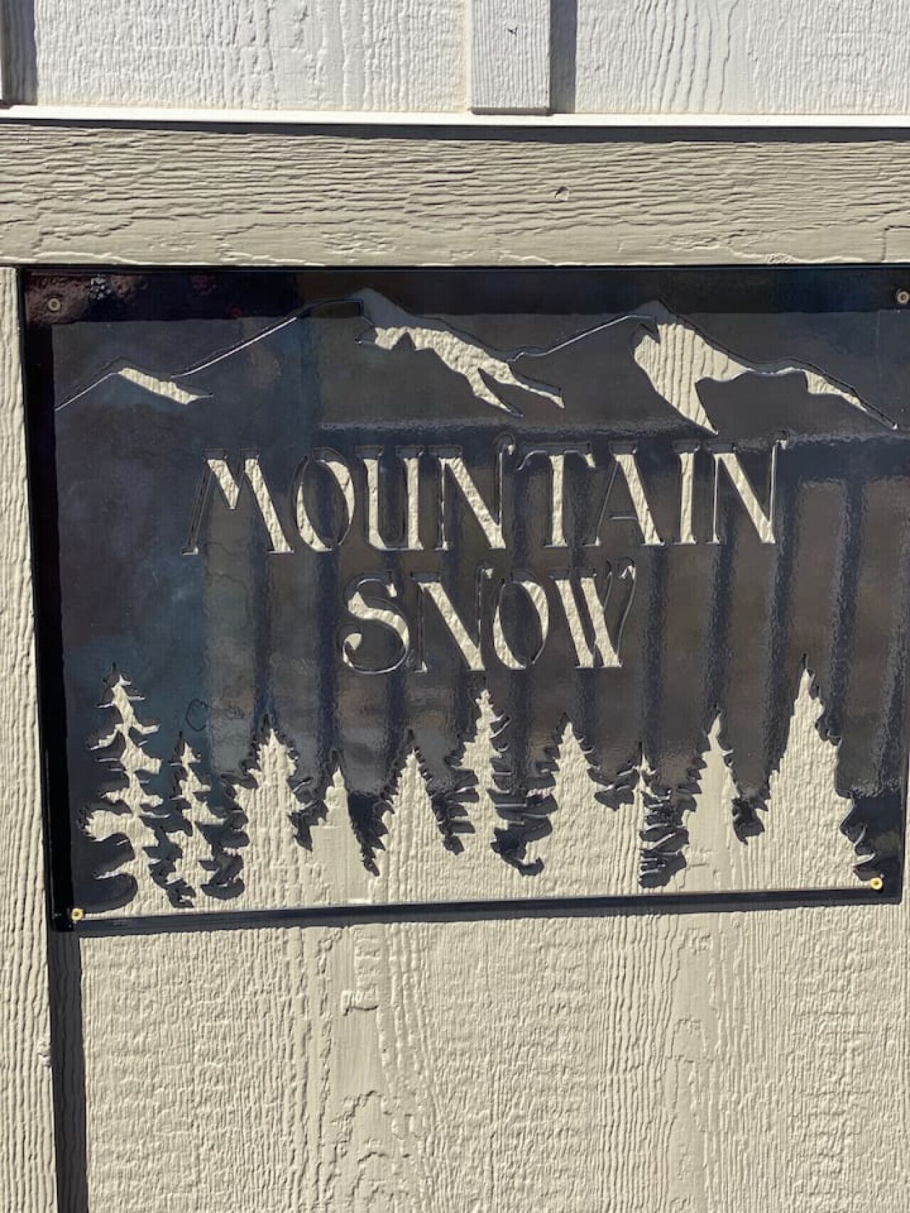 Une enseigne portant les mots « MOUNTAIN SNOW » et représentant des silhouettes de montagnes.