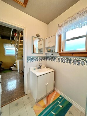 A bathroom with a sink, mirror, and tiled backsplash.