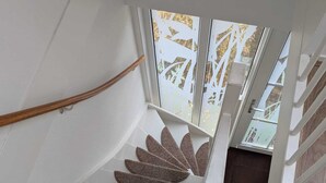 Una escalera con un diseño singular, que presenta una serie de felpudos marrones con forma de hoja en los peldaños.