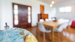 Un comedor con una mesa y sillas de madera, un globo terráqueo sobre la mesa y una puerta al fondo.