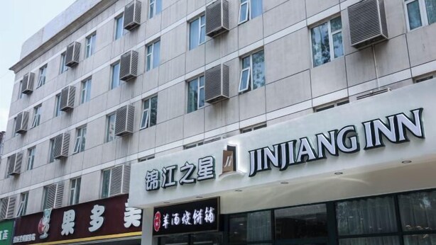 A building with a sign for JINJIANG INN and another sign for a restaurant. - Jinjiang Inn (Beijing Sanyuanqiao Yansha International Exhibition Center Hotel) (Beijing)