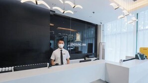 A hotel reception desk with a modern design, a large glass window, and a visible brand name. - Jinjiang Inn (Beijing Sanyuanqiao Yansha International Exhibition Center Hotel) (Beijing)