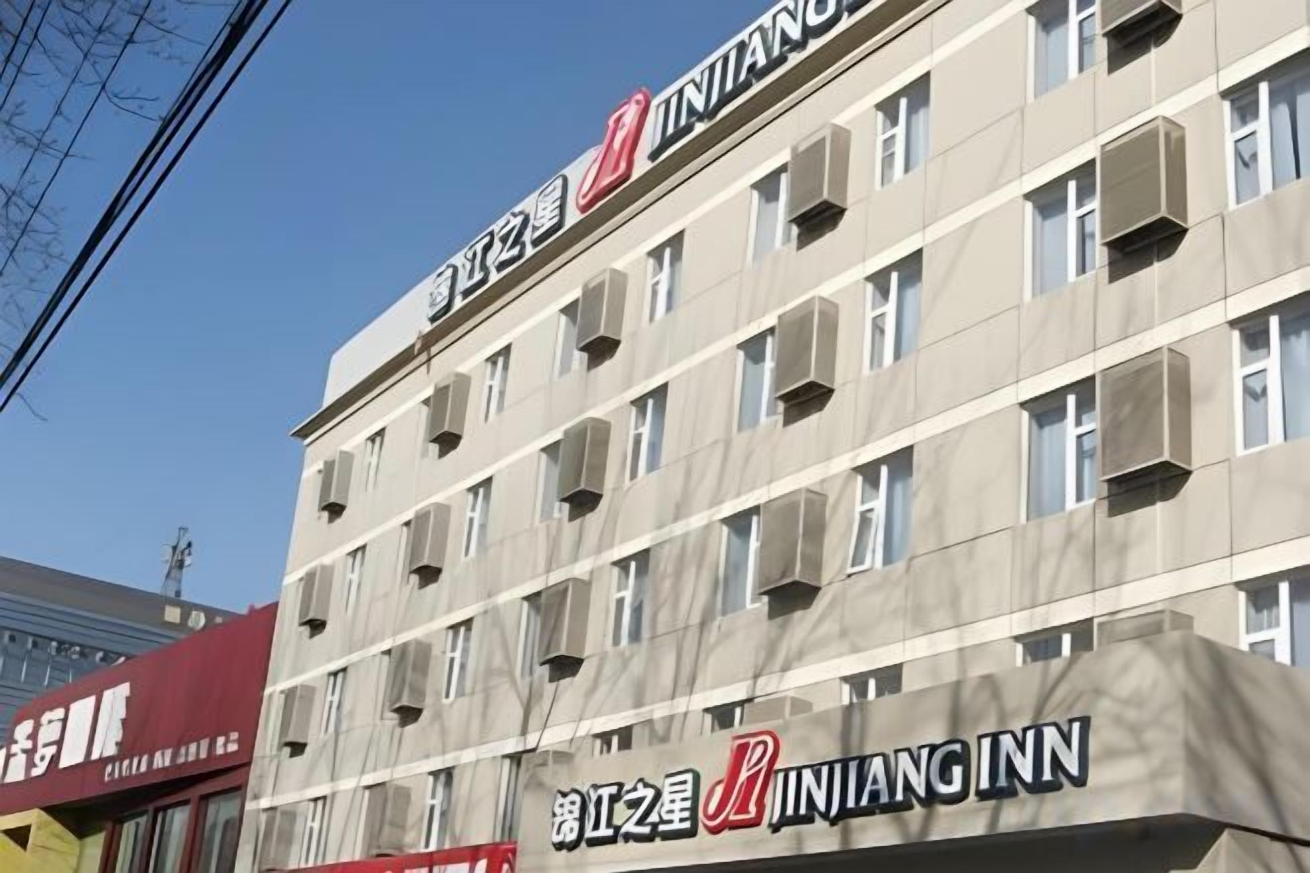 A multi-story building with signage for 'JINIANG INN' and 'JINIANG INN' in large letters.