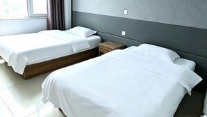 A hotel room with two beds, a nightstand, and a window with curtains. - Song Nantaiting Hotel (Junan County)