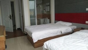 A hotel room with two beds, a wardrobe, and a bathroom visible through an open door. - Song Nantaiting Hotel (Junan County)