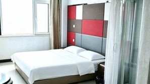 A bed with a headboard, a bedside table, and a window with curtains. - Song Nantaiting Hotel (Junan County)