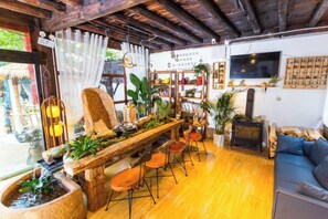 A cozy living room with a wooden coffee table, a blue sofa, and a fireplace. - Lijiang Shu He Shangshanruoshui Inn (Lijiang)