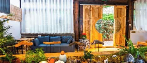 A cozy interior with a sofa, a small table, and a decorative plant arrangement.