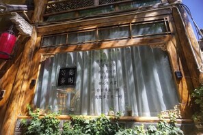 A traditional wooden building with a signboard and a window with curtains. - Lijiang Shu He Shangshanruoshui Inn (Lijiang)