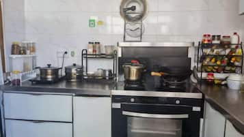 A kitchen with a stove, oven, and various kitchen utensils.