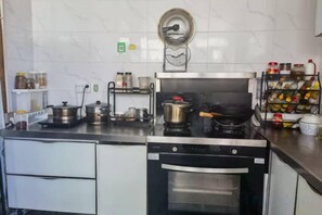 Una cucina con fornello, forno e diversi utensili da cucina.