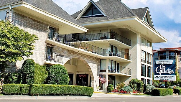 A multi-story hotel with a prominent American flag, balconies, and a sign for the Gillette brand.