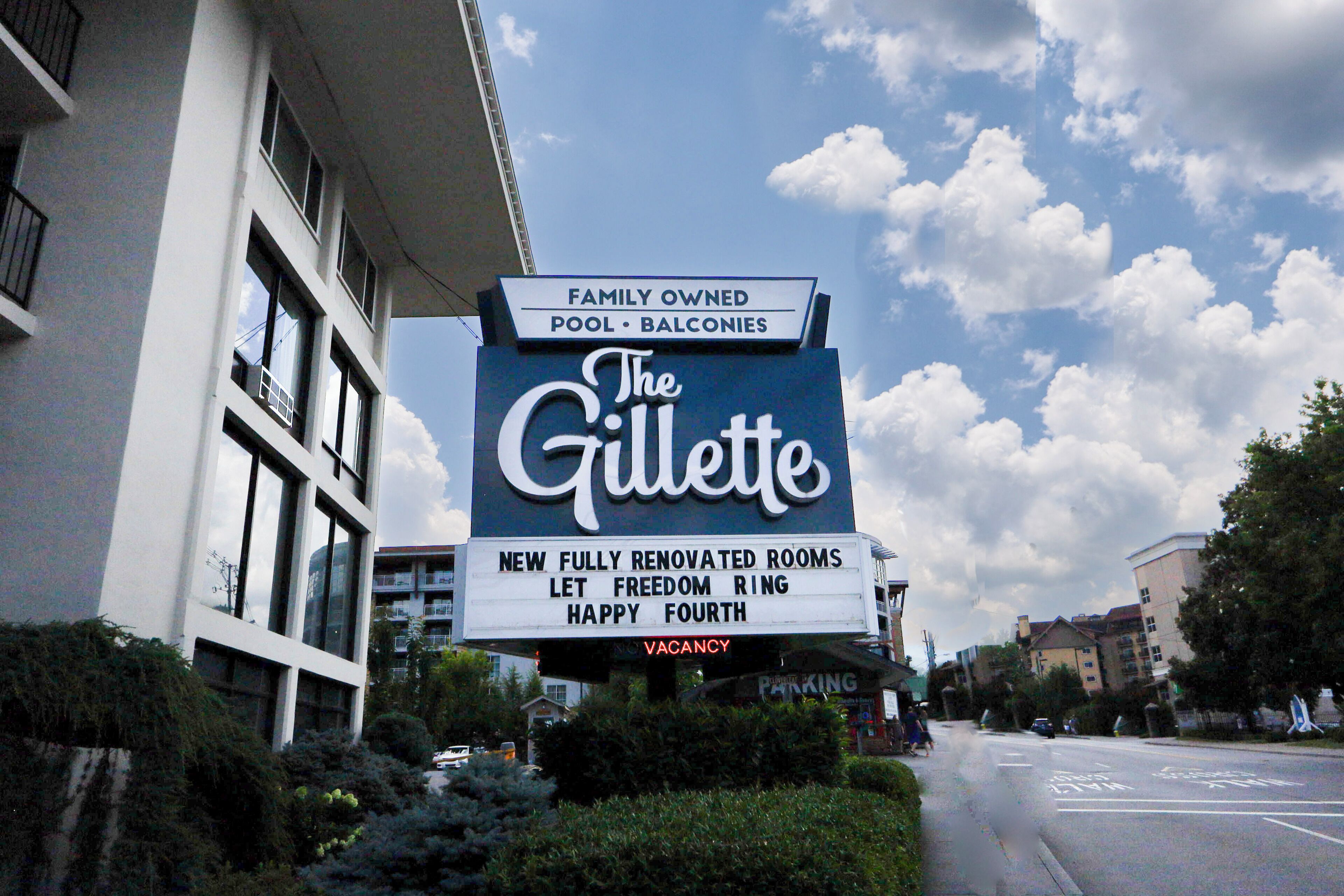 A hotel sign advertising family-owned pool and balconies, new renovated rooms, and a vacancy.