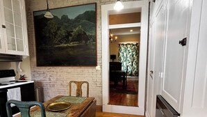 Eine Küche mit einem Holztisch, Stühlen und einem Bild an der Wand.
